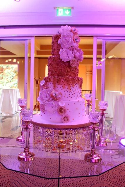 Deep gold textured background with sanding sugars wedding cake